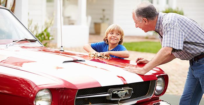 a person and a child looking at a car